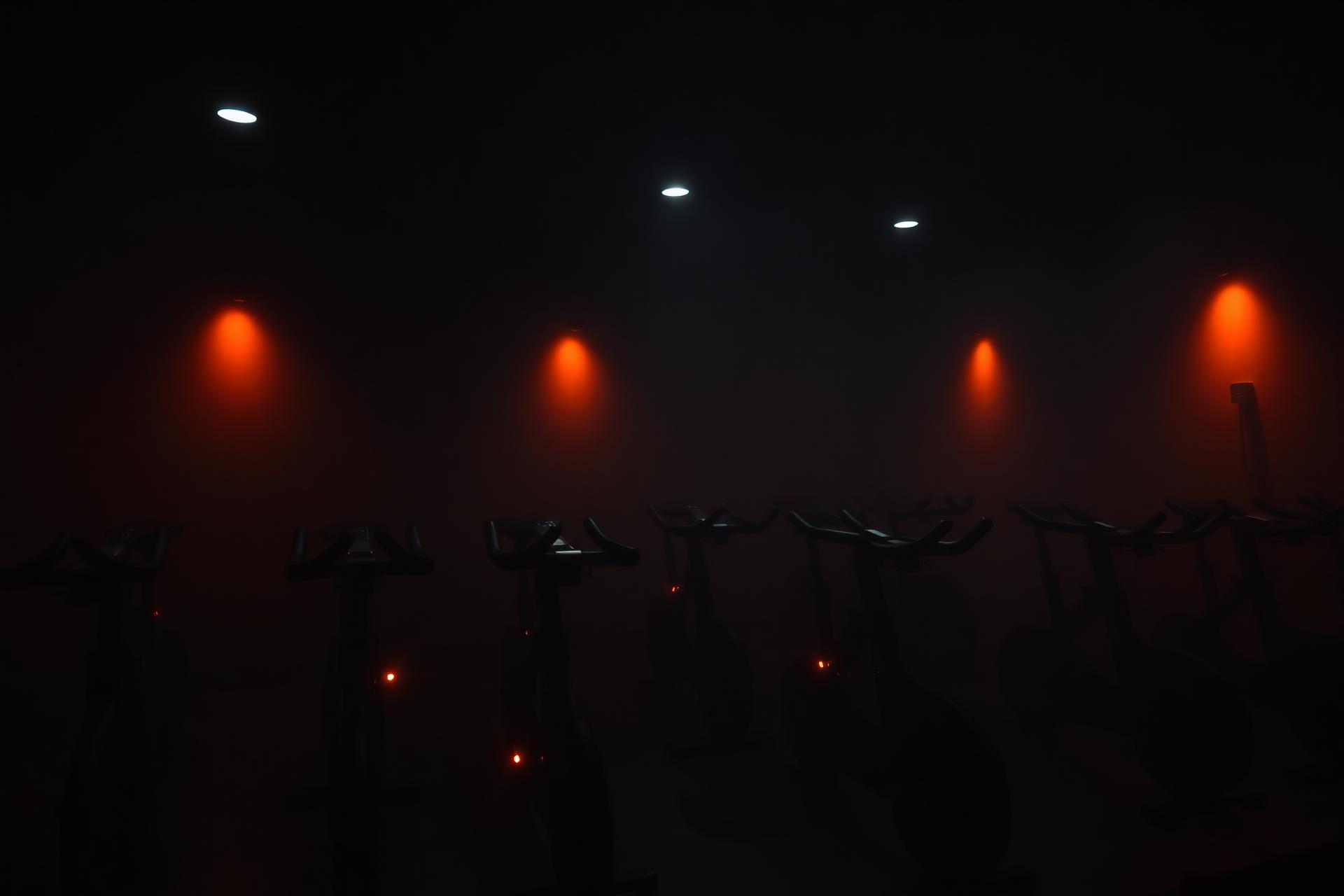 Dark boutique indoor cycling studio lit with warm ember tones